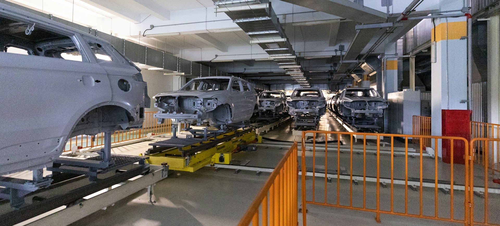 Automotive assembly line with unfinished vehicle frames inside industrial manufacturing facility