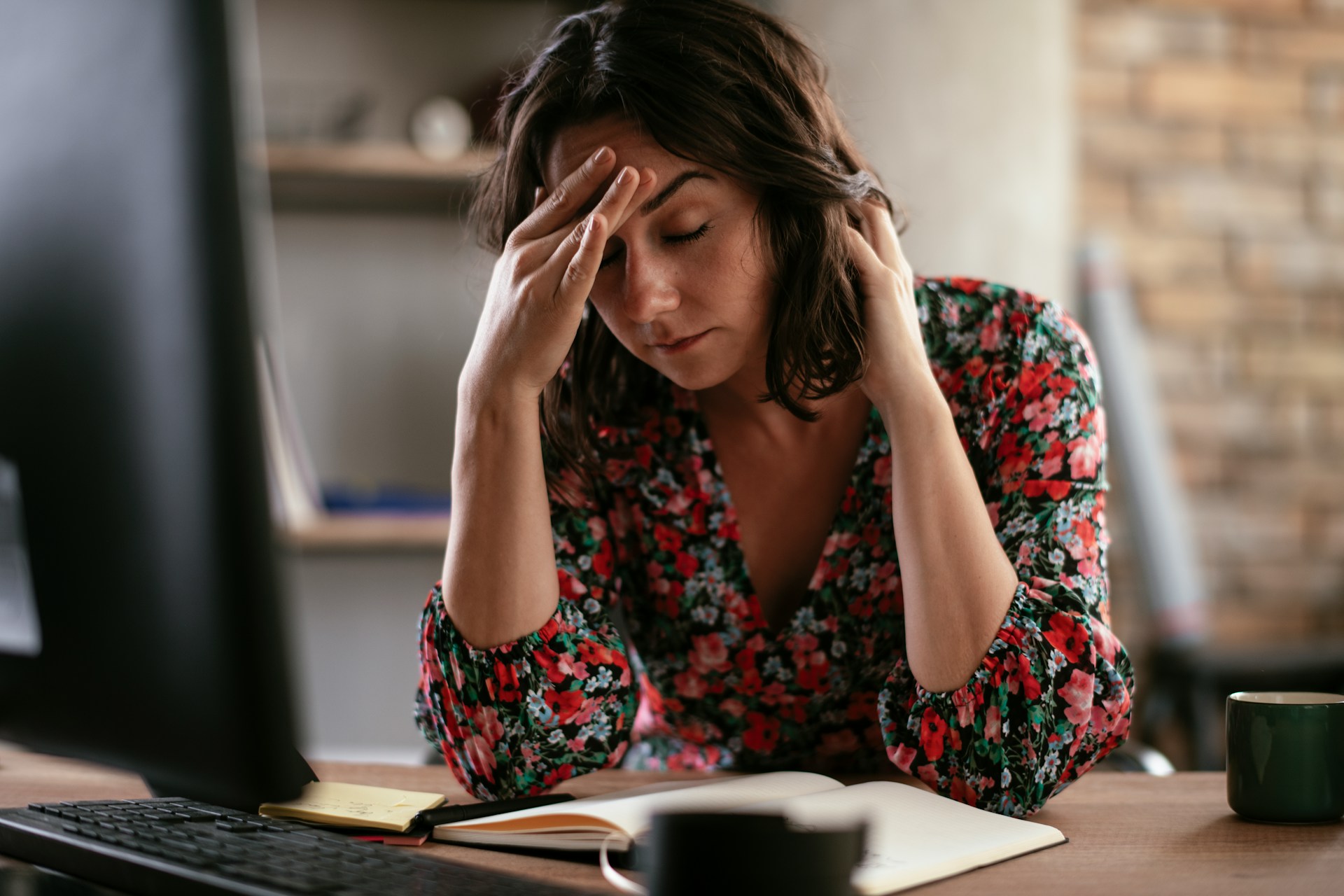 Frustrated homeowner reviewing documents at desk after insurance claim denial