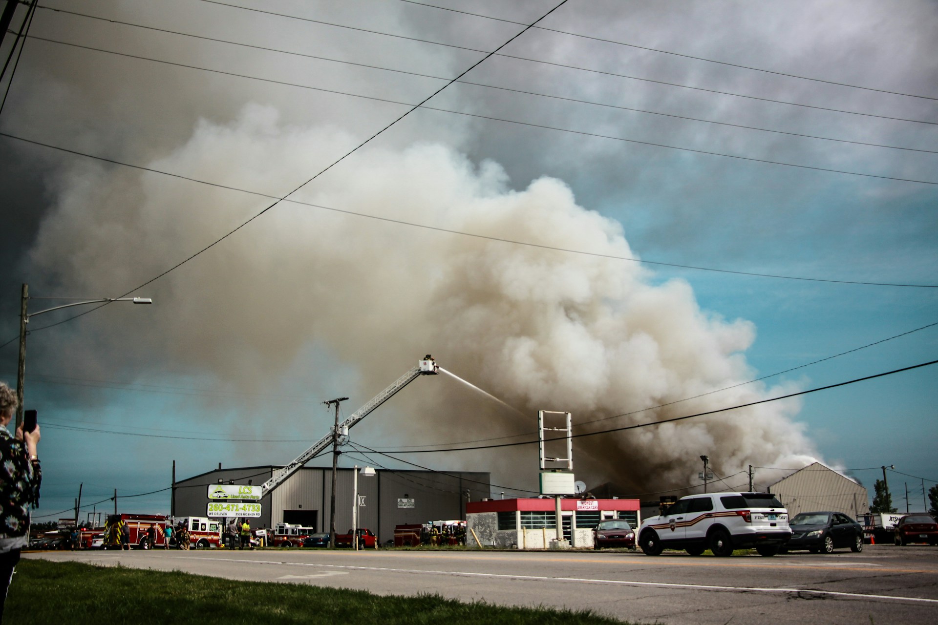 Firefighters responding to large commercial building fire with heavy smoke and active damage