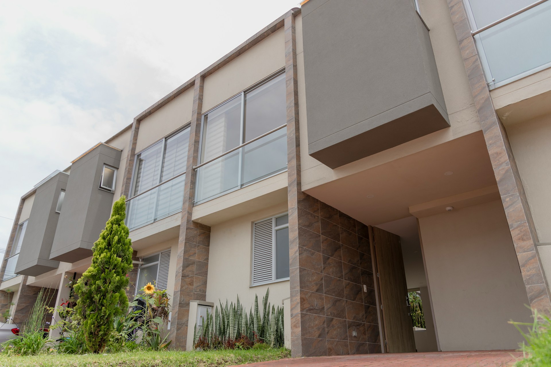 Modern townhouse complex with stone and glass facade representing residential property
