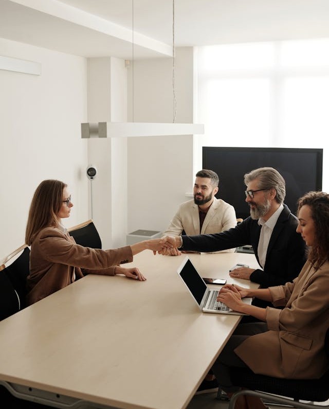Businesswoman shaking hands with a team during partnership meeting