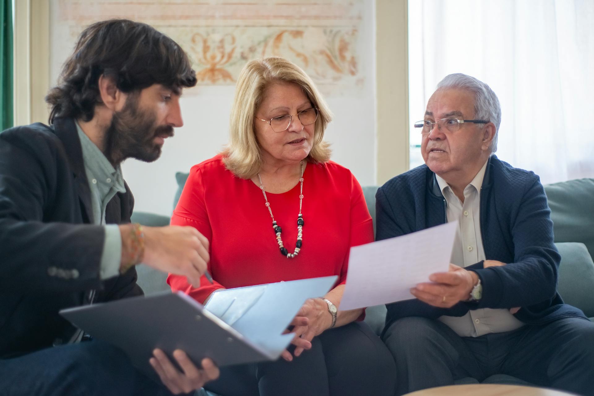 Insurance advisor reviewing documents with an elderly couple at home