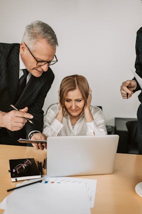 Overwhelmed business owner under pressure during insurance claim review with colleagues