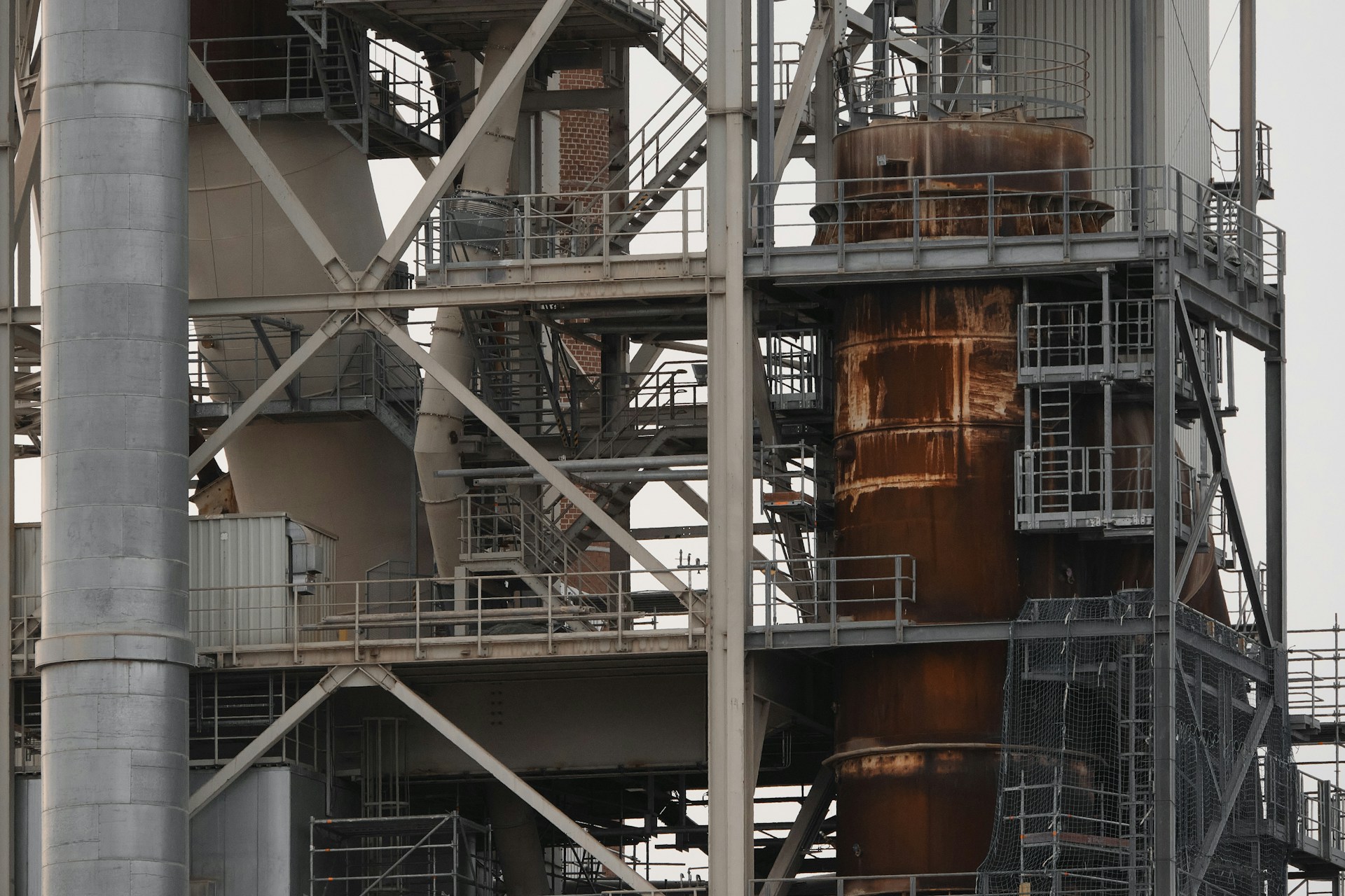 Industrial structure with rusted steel tanks and elevated scaffolding platform