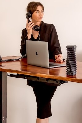 Claims coordinator speaking on phone while managing client file on laptop