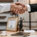 Close up of a professional handshake in an office with legal decor