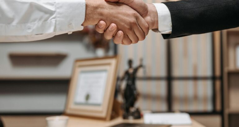 Close up of a professional handshake in an office with legal decor