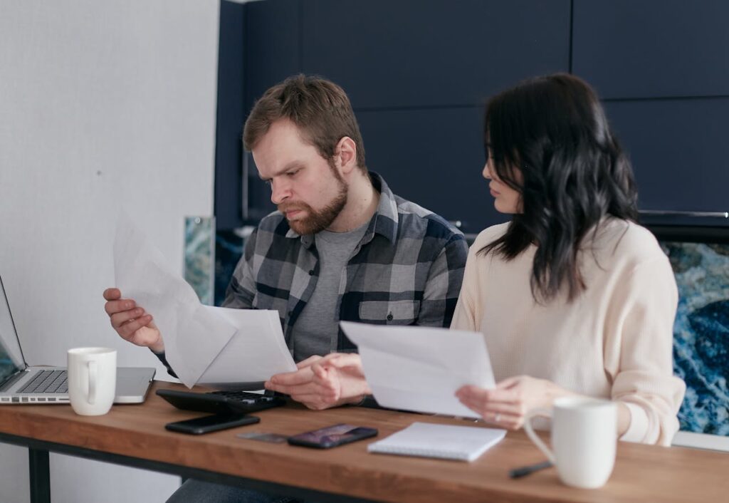 Couple reviewing insurance claim documents and financial paperwork