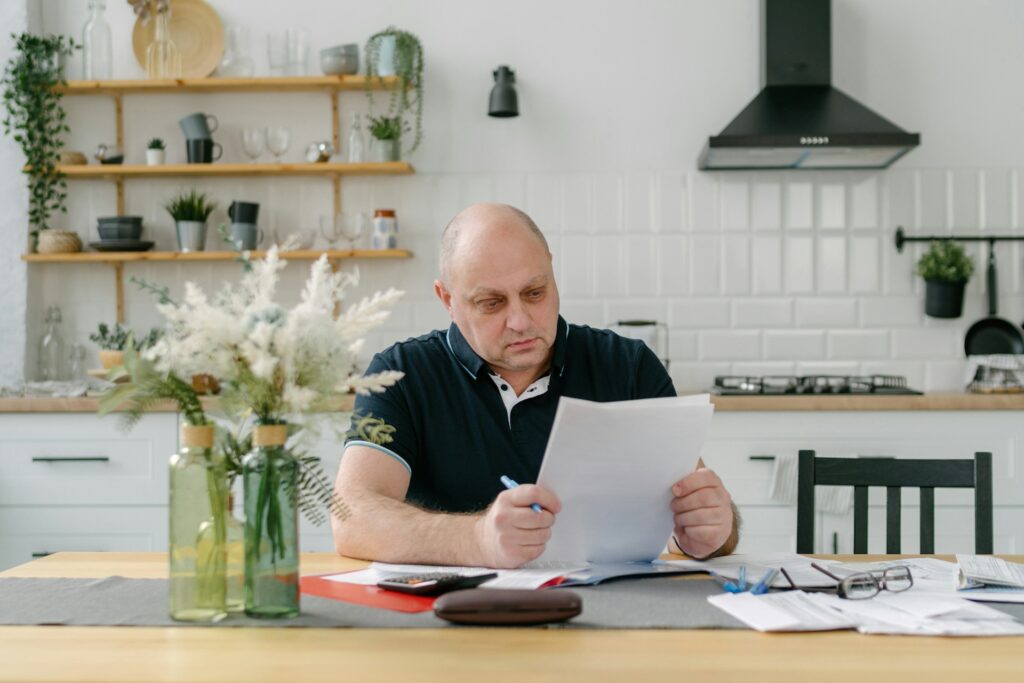 Homeowner reviewing home insurance documents at kitchen table