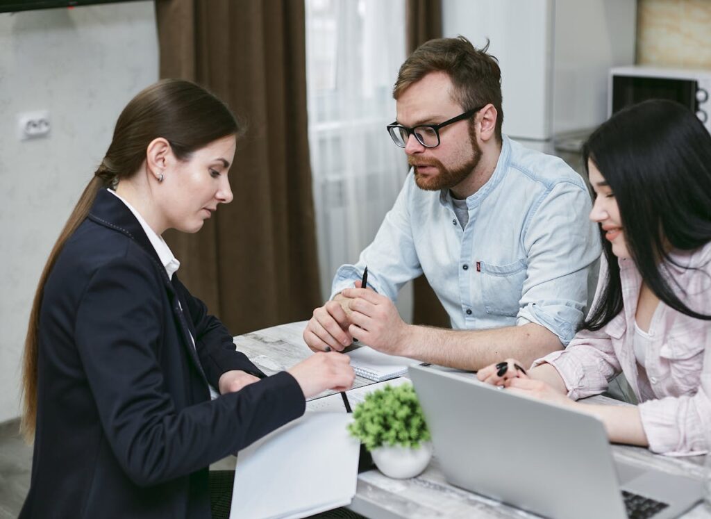 Public adjuster discussing insurance documents with homeowners at a kitchen table