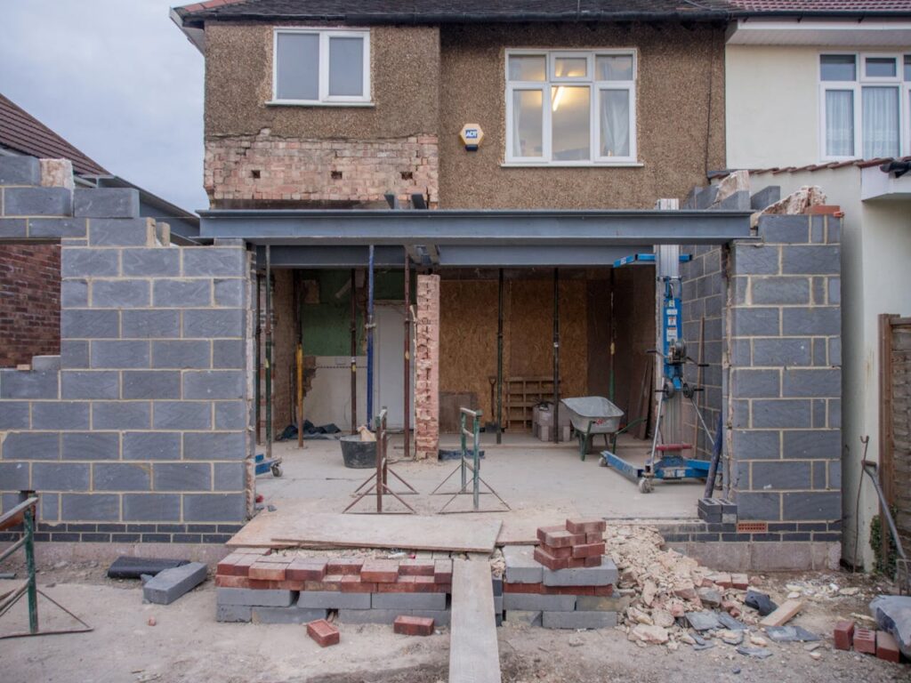 Partially rebuilt house under construction with exposed brick and steel beams