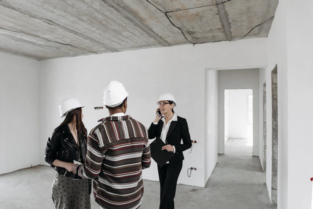 insurance adjuster and homeowners discussing code-compliant repairs inside damaged home