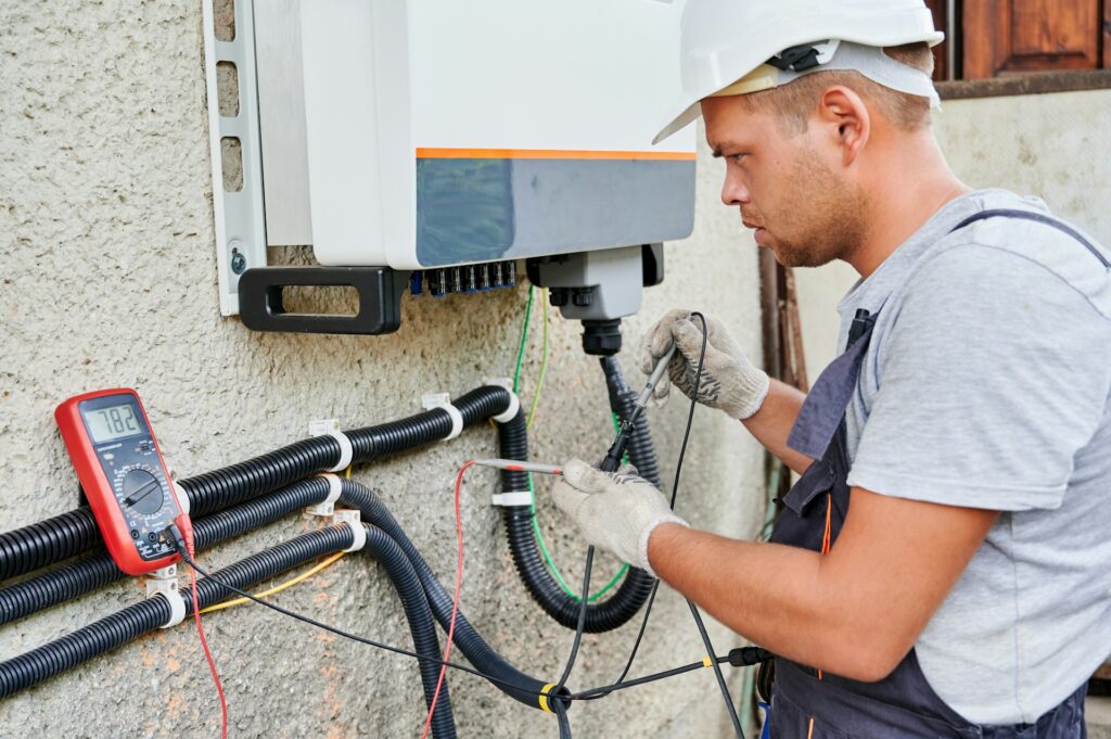 Electrician upgrading wiring to meet building code standards after disaster