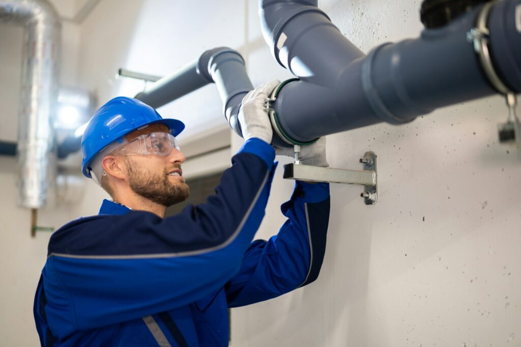 Skilled worker inspecting or repairing commercial piping