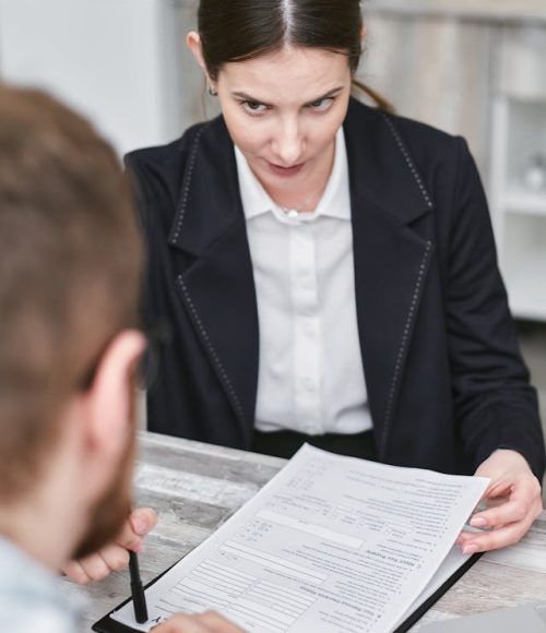 Insurance advisor reviewing claim paperwork with a client across the table, preparing documentation for submission.